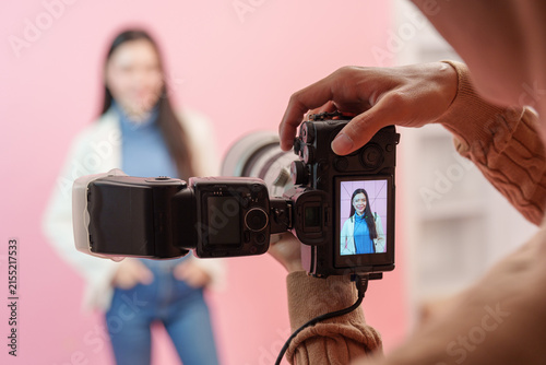 Camera screen displaying portrait preview of female model during photoshoot in studio