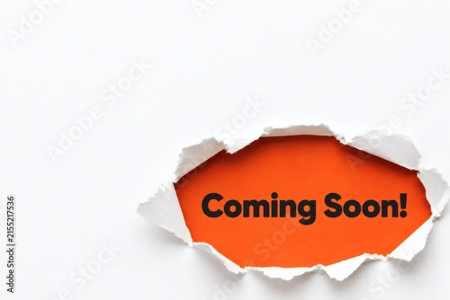 Teaser Torn Paper: A bright orange background peeks through a torn paper advertisement, announcing Coming Soon! creating anticipation and curiosity