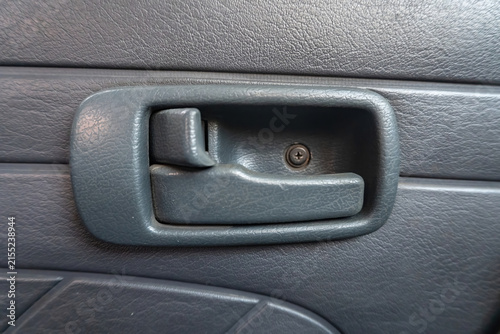 Obraz na płótnie Detailed close up of a classic car interior door handle and lock lever on a textured panel, highlighting retro vehicle hardware, security mechanisms, and design