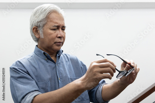 Photography Sad Asian old senior man with eyesight problem, concept image of aging eye sight