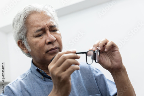 Photography Sad Asian old senior man with eyesight problem, concept image of aging eye sight