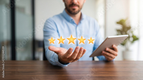 Businessman presenting a five-star rating while holding a tablet. Represents excellent customer service, feedback, and top quality