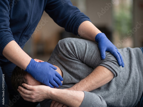 Emergency First Aid Responder Placing Injured Man in Recovery Position