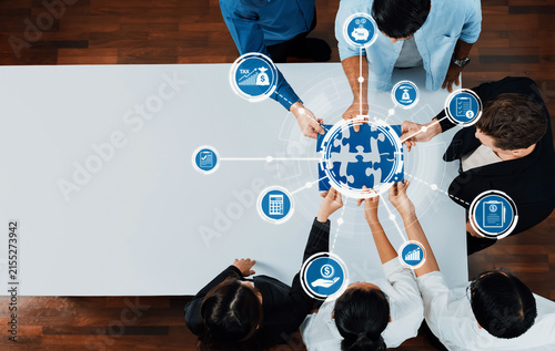 Картината върху платно A group of diverse professionals collaborates over a puzzle globe, representing finance and tax solutions, in a modern office environment focused on teamwork
