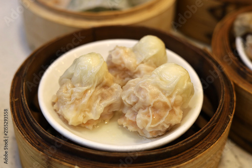 Photography Quail egg dim sum dumplings served hot in a bamboo basket.