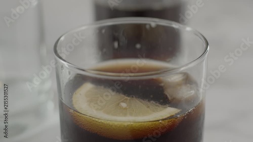 Adding lemon slice into glass with soda and ice. Original sound. 24fps. Prores 422HQ