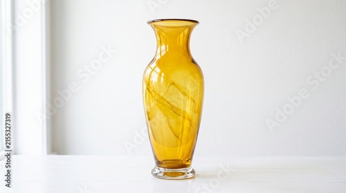 Elegant amber glass vase glowing softly near window, symbolizing warmth, craftsmanship, and timeless beauty.