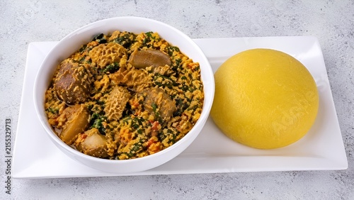 Traditional Nigerian Egusi Vegetable Soup Served with Yellow Eba (Garri)