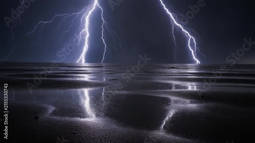 Powerful lightning bolts illuminate a dark night sky and reflect on the wet surface of a.