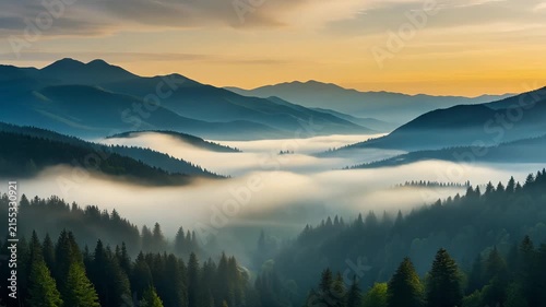 Dense morning mist settles between blue mountain peaks under a warm golden sky.