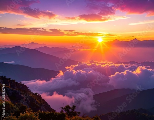 A breathtaking sunset illuminates a mountainous landscape, casting vibrant colors across the sky and clouds.