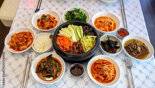 Traditional Korean Dolsot Bibimbap in Hot Stone Pot with Assorted Banchan Side Dishes and Kimchi