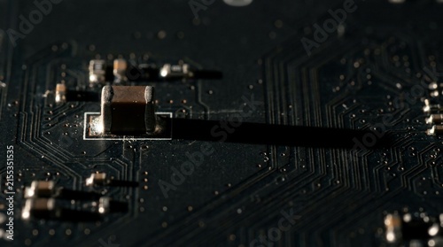 Macro view of surface mount electronic components on a dark printed circuit board.