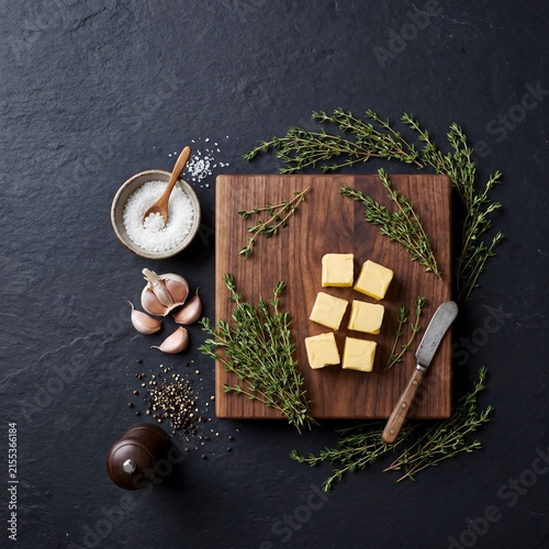 Fresh thyme garlic and butter on wooden cutting board