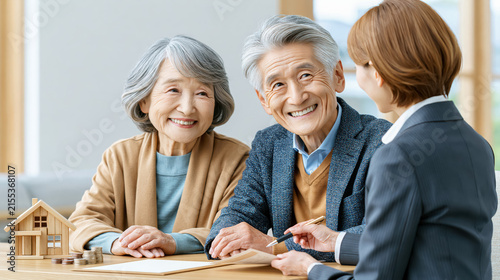 Elderly Japanese couple financial consultation home model house coin stack document smiling advisor