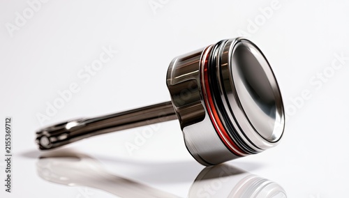 Close-up of a Shiny Metal Piston with Red Accents on a White Background.