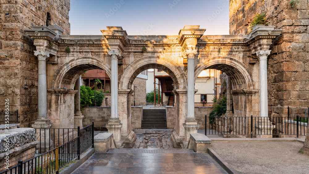 Fototapeta premium The ancient Roman Hadrian's Gate with its three arches and Corinthian columns standing in the historic Kaleici district of Antalya, Turkey during a sunny afternoon