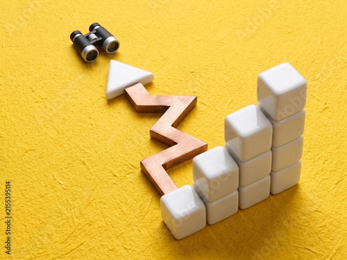 Business Growth Concept with Rising Bar Chart, Wooden Arrow and Binoculars on Yellow Textured Background