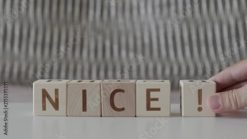 nice !, motivational word, laying out  by hand from letters on wooden cubes, slow motion
