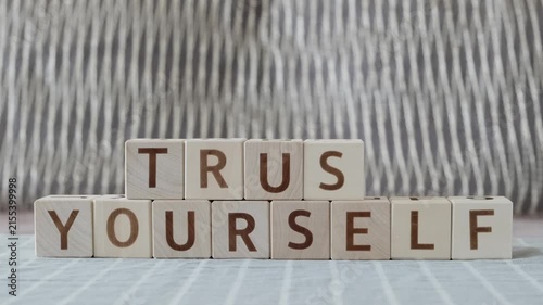 trust yourself, laying out  by hand from letters on wooden cubes, slow motion
