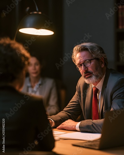 Mature lawyer explains car accident details to concerned female client