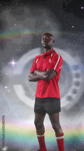 Animation of rugby player standing with arms crossed over glowing light with prism in background