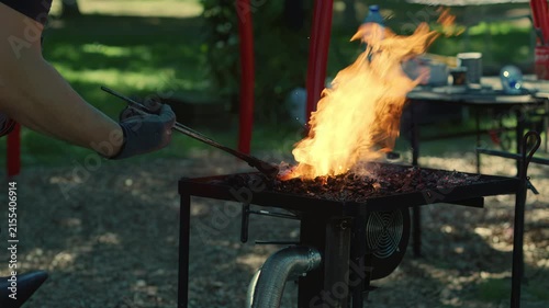 Blacksmith Heating Metal with Tongs