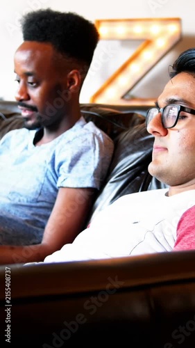 Animation of rainbow heart over gay couple using electronic devices