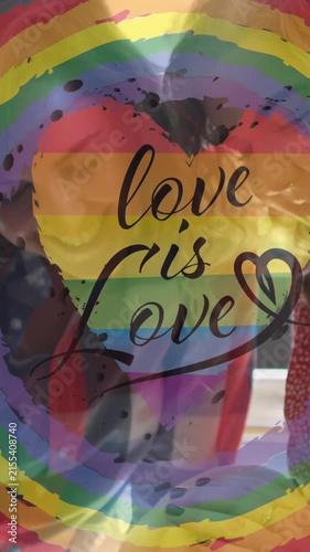 Animation of rainbow circle and love is love over lesbian couple petting dog