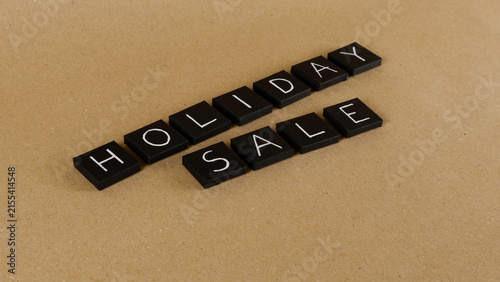 Obraz na płótnie Black letter tiles forming the words holiday sale are arranged diagonally on a t