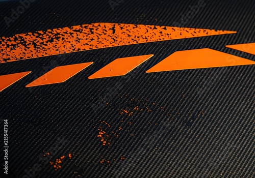 Abstract orange and black textured background with diagonal lines and geometric shapes.