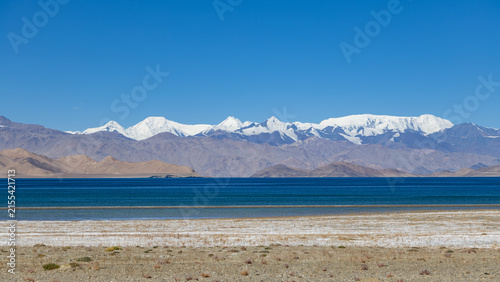 Quadro su tela Panoramic view of deep blue Karakul Lake with snow-capped mountain range in East