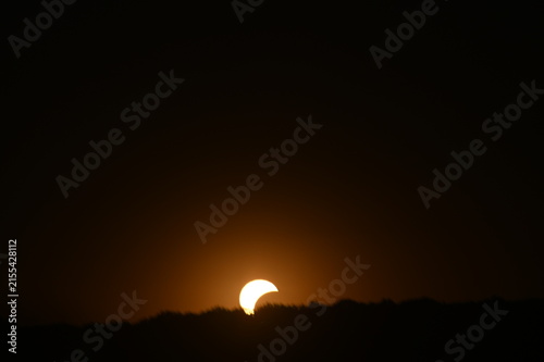 Partial solar eclipse visible in the daytime sky, with the Moon covering part of the Sun and creating a dramatic celestial phenomenon. Czech epublic, Silesia, Hnevosice, 12-September 2026
