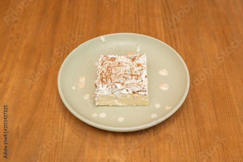 Foto Tres Leches Cake Slice Topped with Whipped Cream and Cinnamon on Sage Green Plat