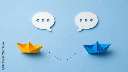 Yellow and blue paper boats moving towards each other below speech bubbles for business partnership