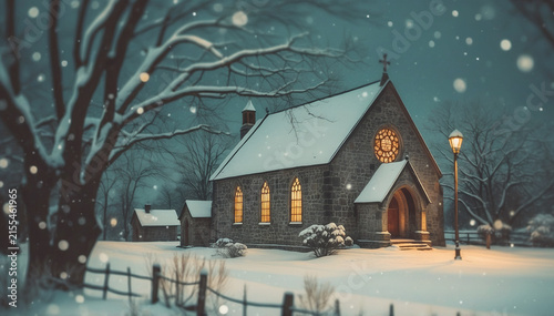 Magical night scene of an old country church amidst frozen evergreen trees and falling snow.