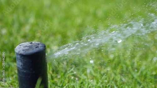 A close-up of a garden sprinkler spraying water and water droplets in slow motion 300fps