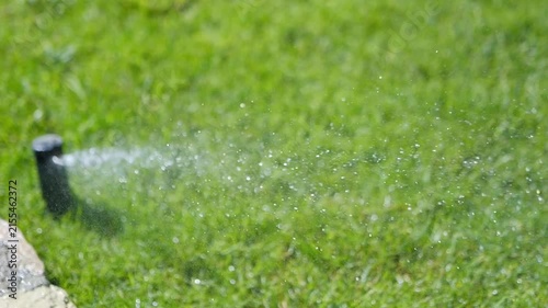 A close-up of a garden sprinkler spraying water and water droplets in slow motion 300fps
