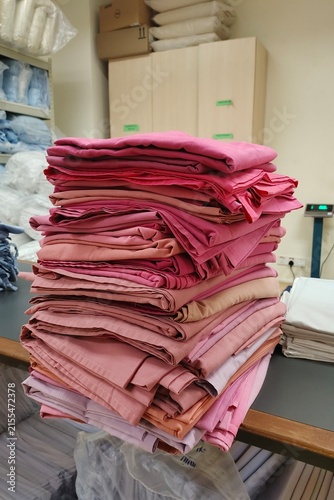 stack of neatly folded hospital linen prepared for use in a healthcare facility