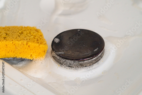 Canvastavla Photo of manual cleaning of the surface of a gas stove from small dirt with a cl