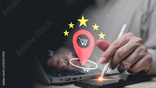 Online shopper using laptop and digital tablet with location pin, shopping cart and five star ratings, representing local ecommerce, store discovery, customer reviews and retail navigation technology.