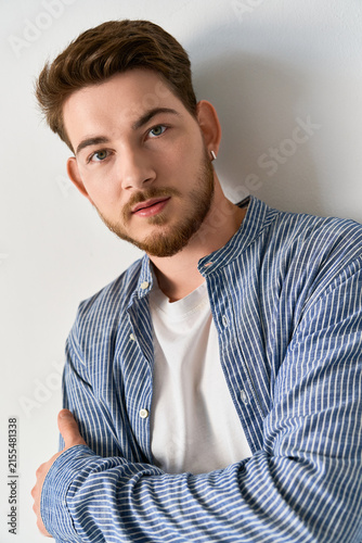 Фотография Stylish young man in casual attire exuding confidence in a modern studio setting