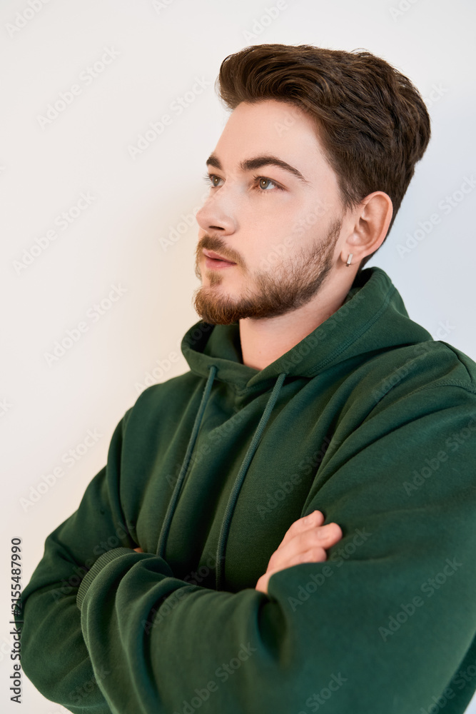 Obraz premium Stylish young man with beard showcases casual fashion in modern studio setting