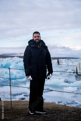 Full-Length Portrait of Male Traveler Standing at Icelandic Glacier Lagoon