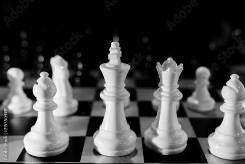 Canvastavla White chess king and queen on black and white board with bishop and pawns in sha