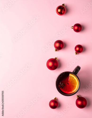 Cup of Mulled Wine with Red Baubles on Pink Background