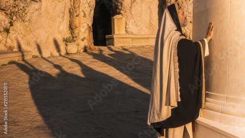 Biblical man in ancient robe touching a temple wall, symbolizing spiritual reflection, religious tradition, and the contrast between outward ritual and inner faith from Luke Gospel chapter 11
