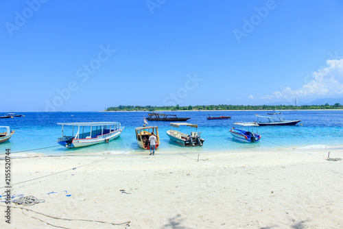Tropical Gili Trawangan beach with boats on turquoise water in Lombok Indonesia