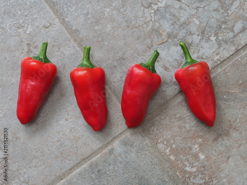 Sweet red peppers, variety Lipstick, on a tiled background