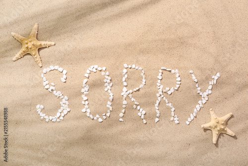 Cuadro en lienzo Word SORRY made of pebbles with starfishes on sand